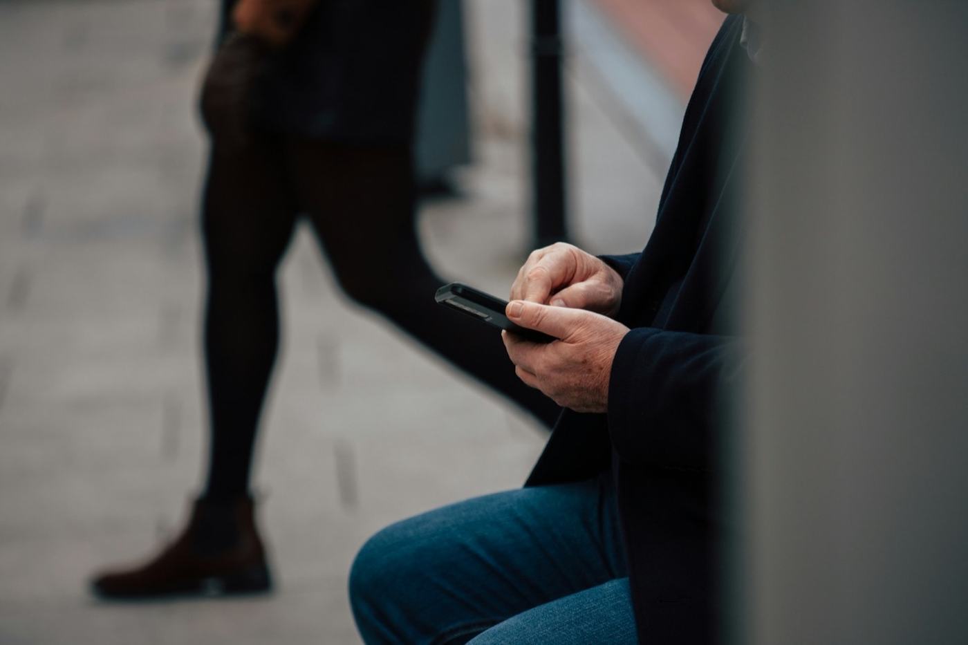 Telefon z otwartą mapą na tle miejskiej ulicy