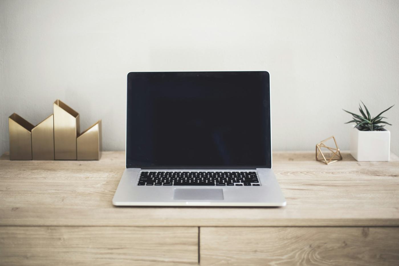 Laptop na drewnianym biurku w jasnym pomieszczeniu
